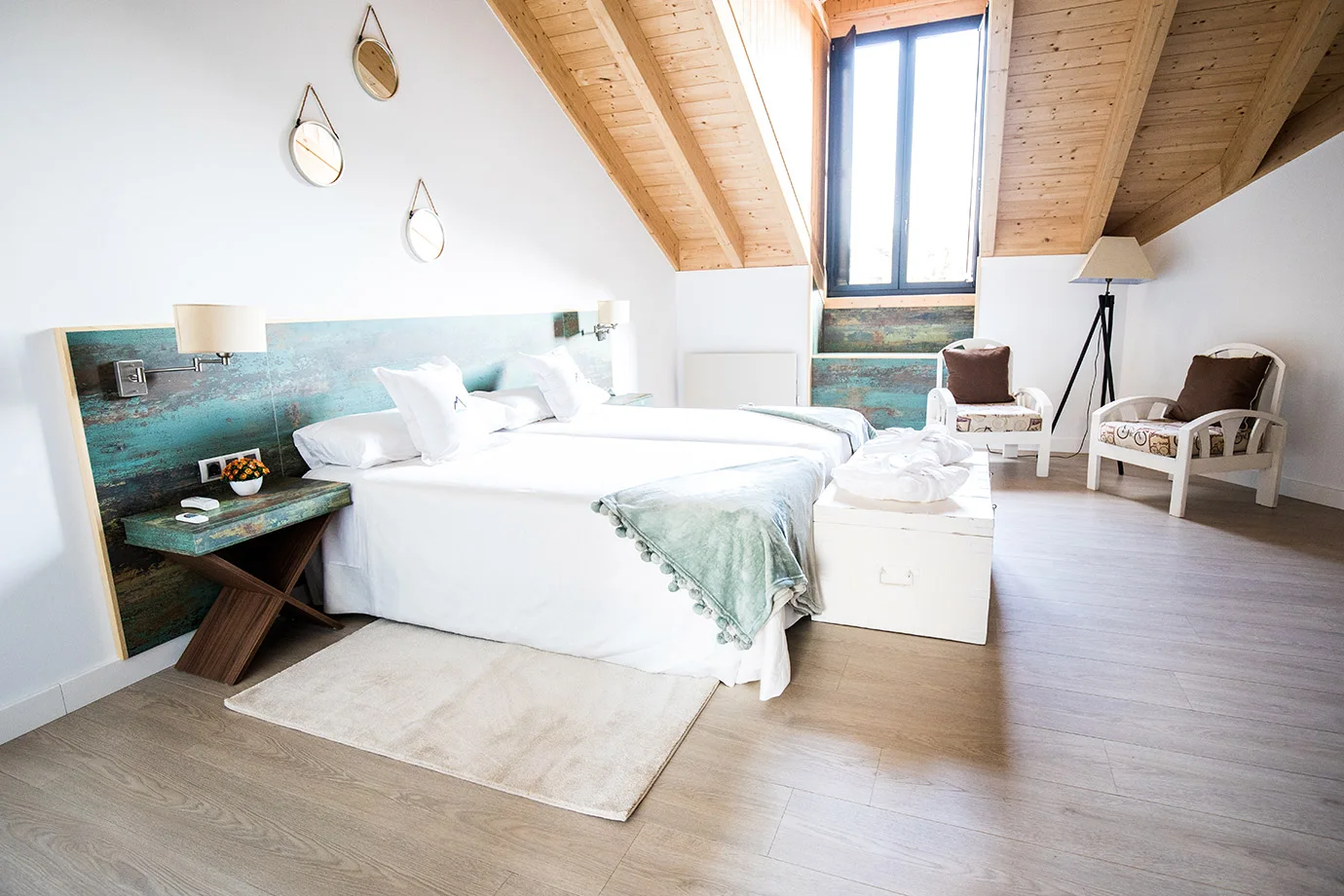 Habitación abuhardillada con cama y ventana