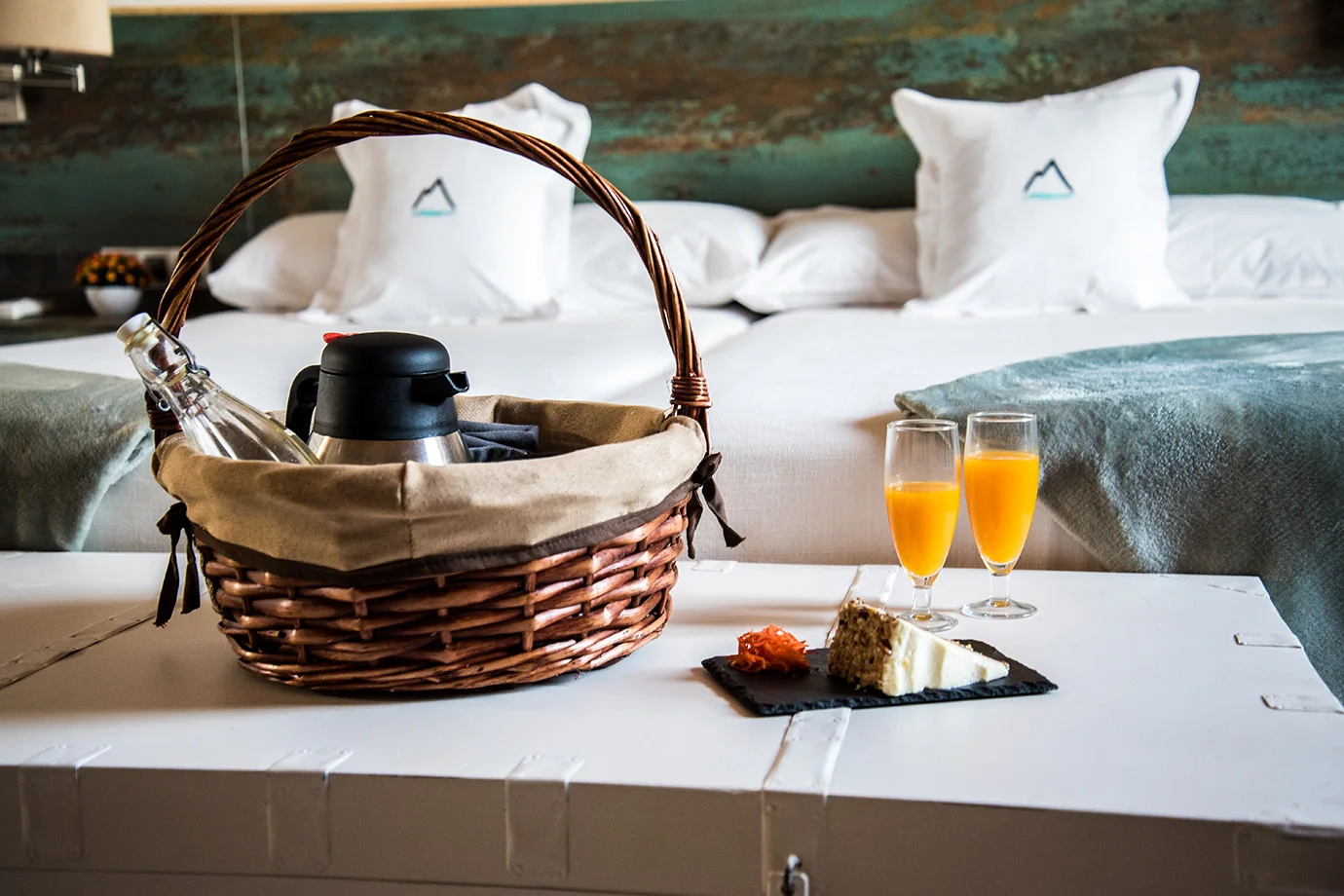 Cesta de desayuno con zumos sobre la cama