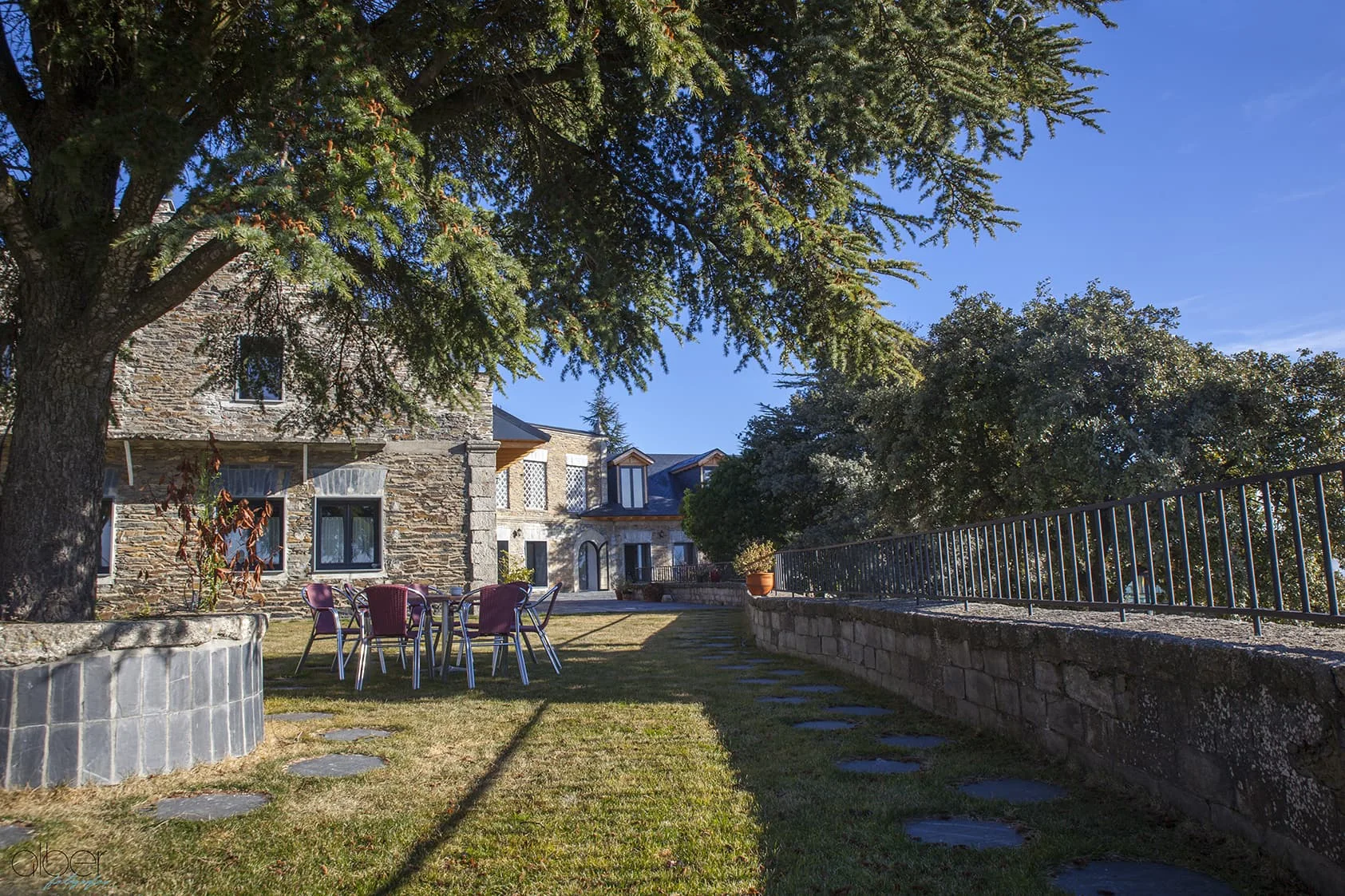 La casa de piedra con su terraza ajardinada